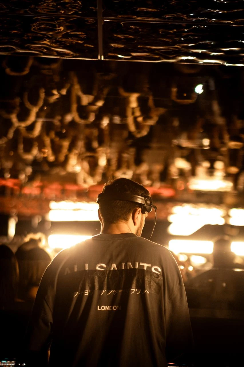 MEIDA backstage wearing headphones under warm lights
